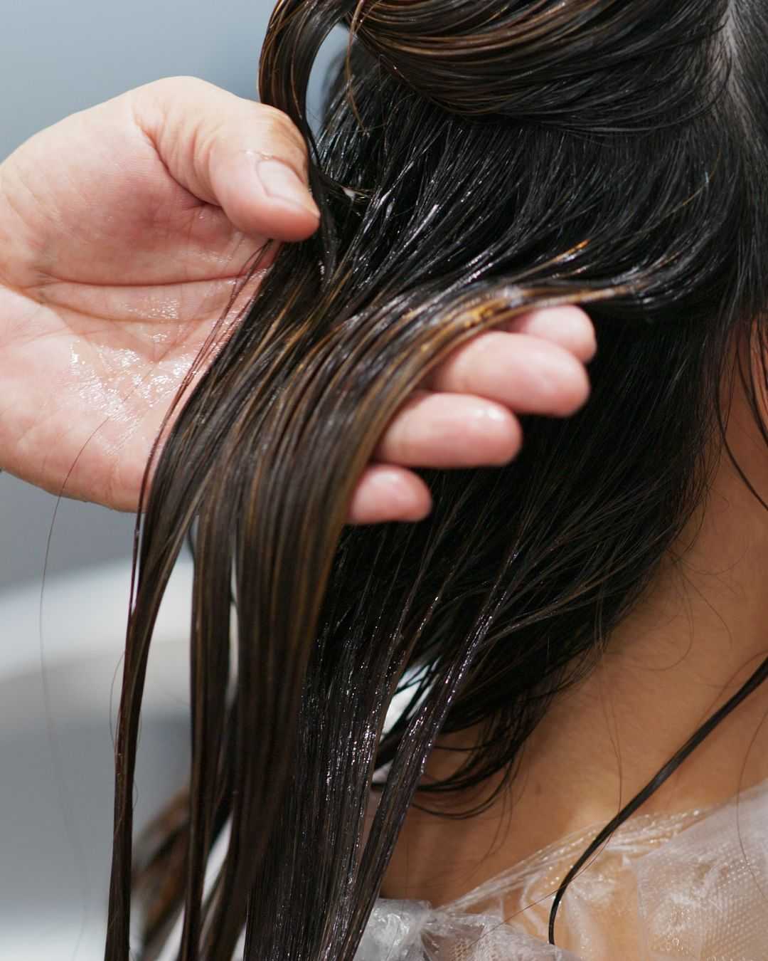 Wet hair being prepared for a treatment in a salon setting.